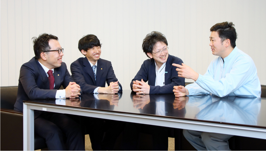写真:4人テーブルの上で、笑顔で話をしている様子。